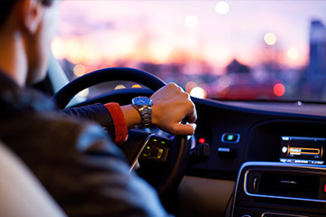 Mann von hinten beim Auto Fahren